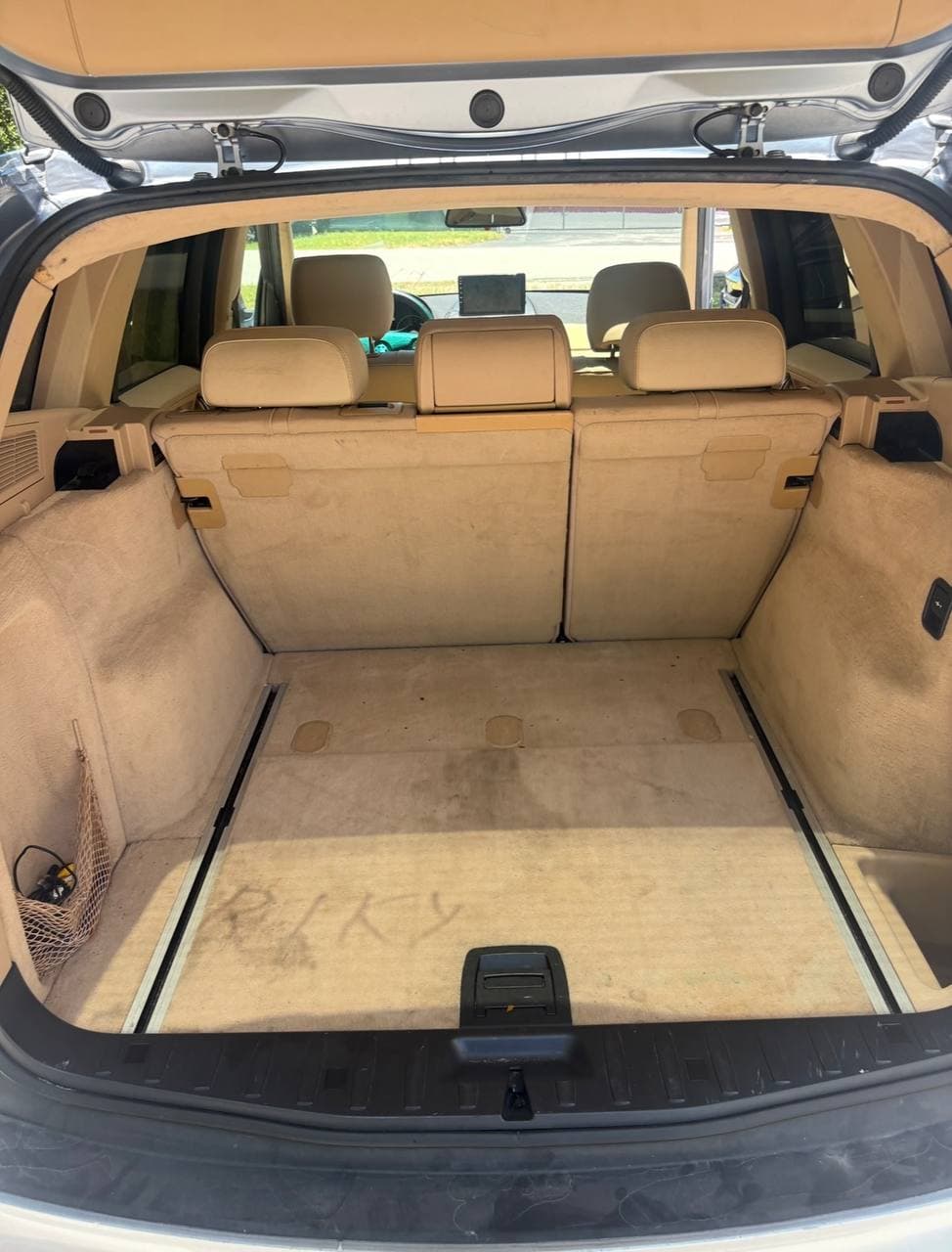 Before mobile detailing showing a dirty beige SUV cargo area